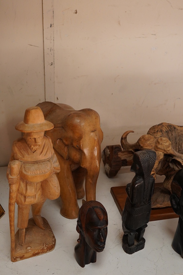 A collection of mostly Eastern and African carved wood figures to include three giraffes, a buffalo and African busts